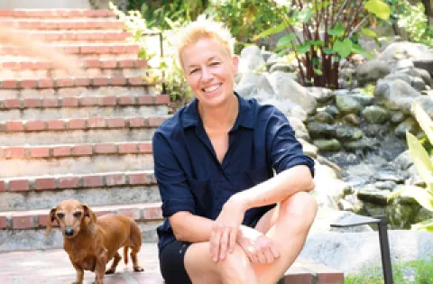 Woman sitting on stairs by a little dog