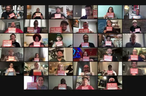 Multiple faces on Zoom meeting with No Kid Hungry sign